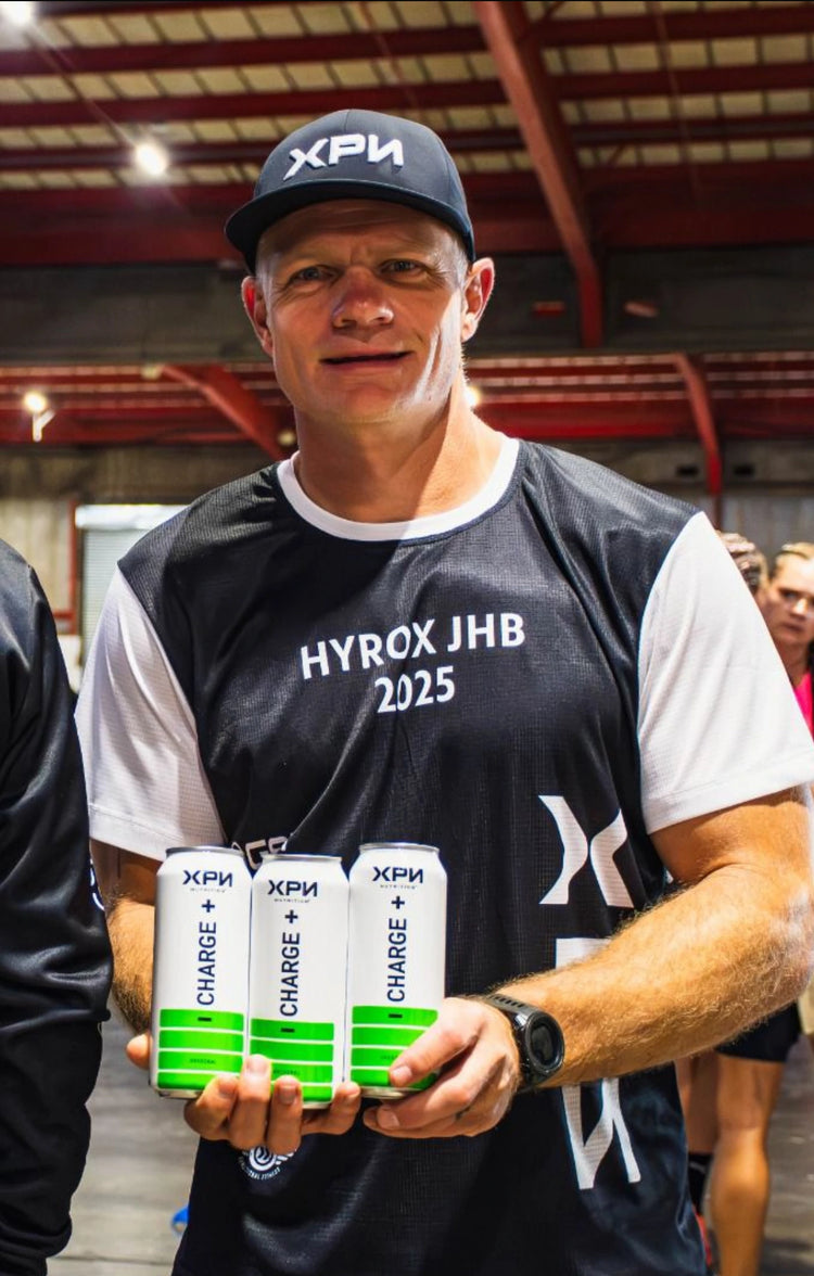 Deon Van Rensburg holding XPN products in a gym setting